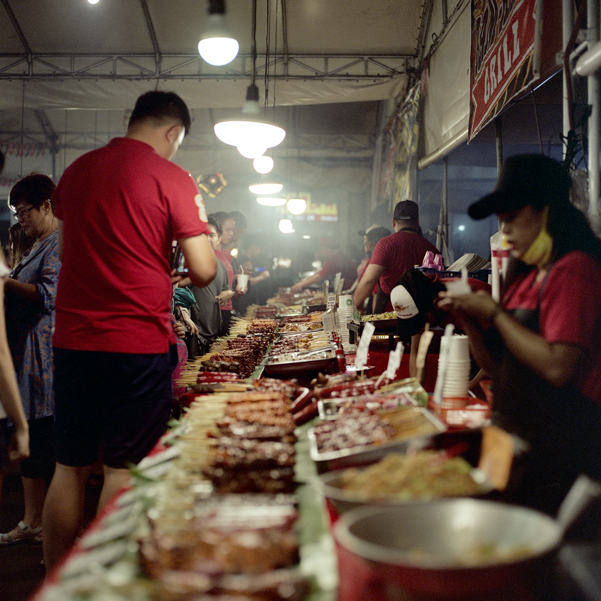 Looking down the row of all the food options at a night market