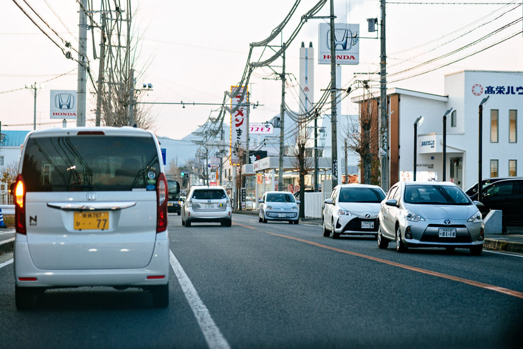 Cars driving by on a road in Nara Japan at sunset